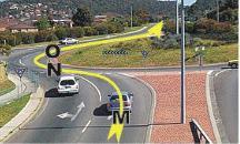 Intersections - You are in the right hand lane and are planning to go straight ahead through this roundabout. When should you signal left to exit the roundabout?