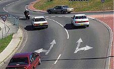 Intersections - When turning left at a roundabout you should enter and leave the roundabout: